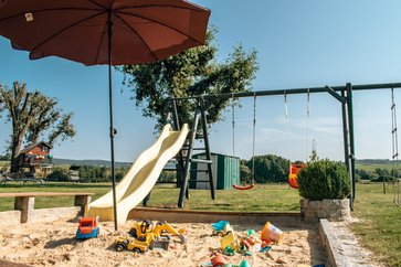 Spielplatz, Sandkasten, Sonnenschirm, Rutsche und Schaukel zum Spielen im Garten