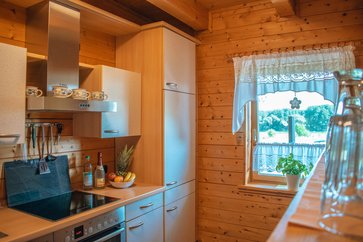 Küche: Kühlgefrierkombi, E-Herd, Kaffeemaschine im Holzhaus