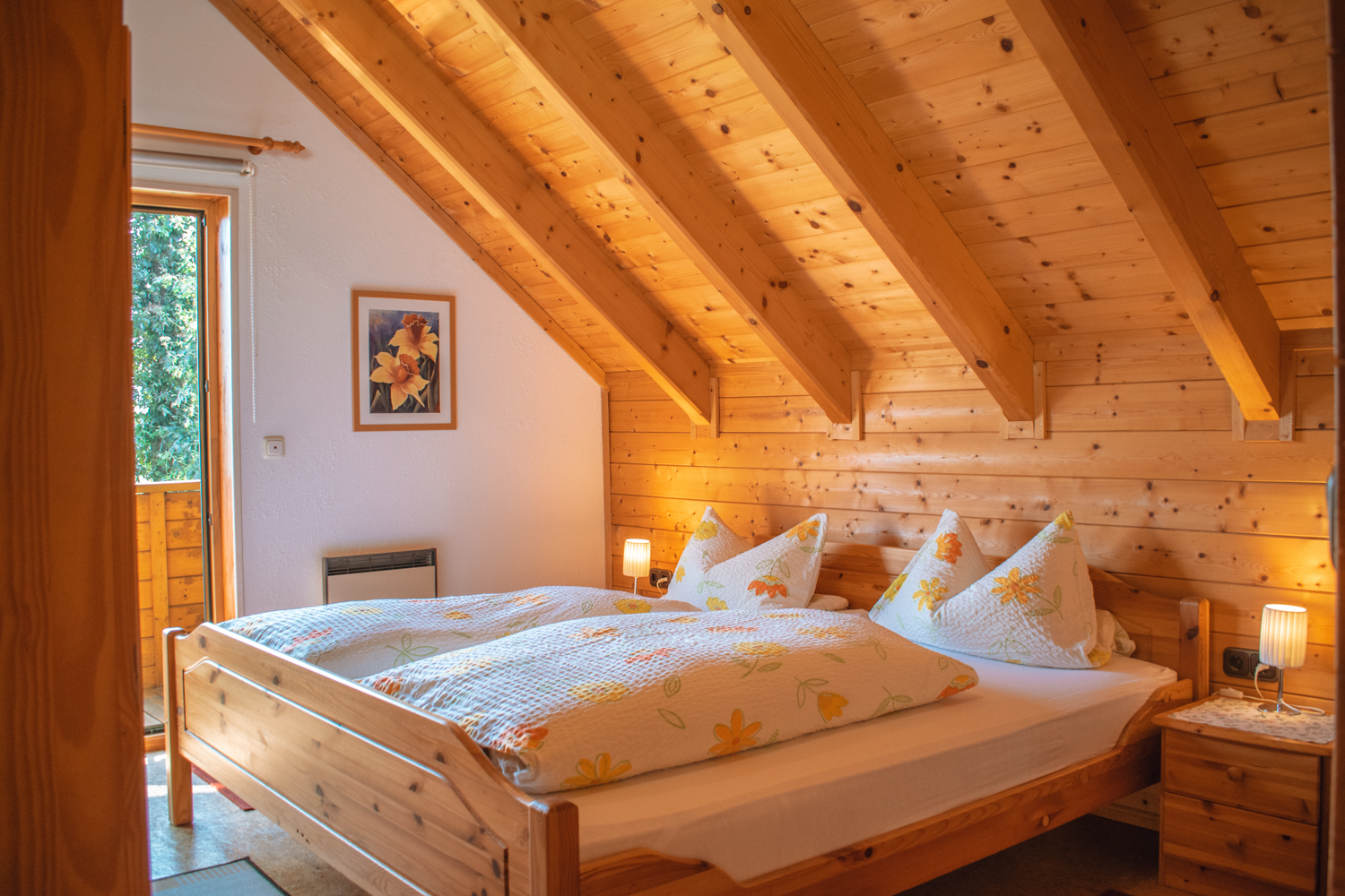 holz-Dachschrägen im Schlafzimmer mit Doppelbett und Balkontür
